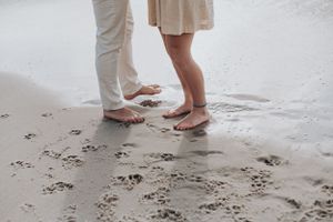 Bare feet in the sand during an intimate beach moment.