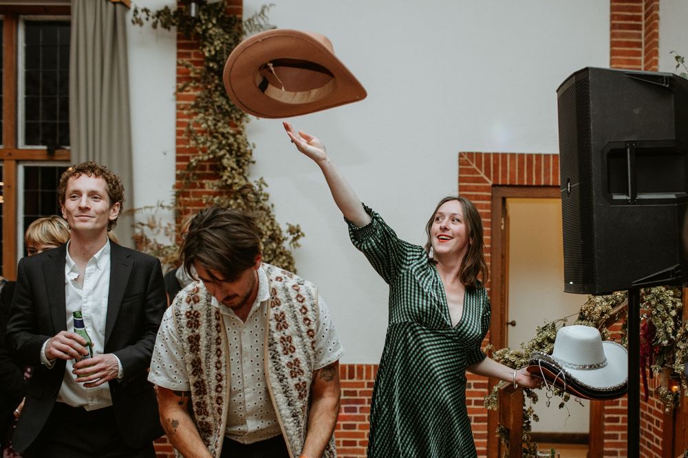 People celebrating and dancing together at a lively indoor party with brick walls and festive decorations.