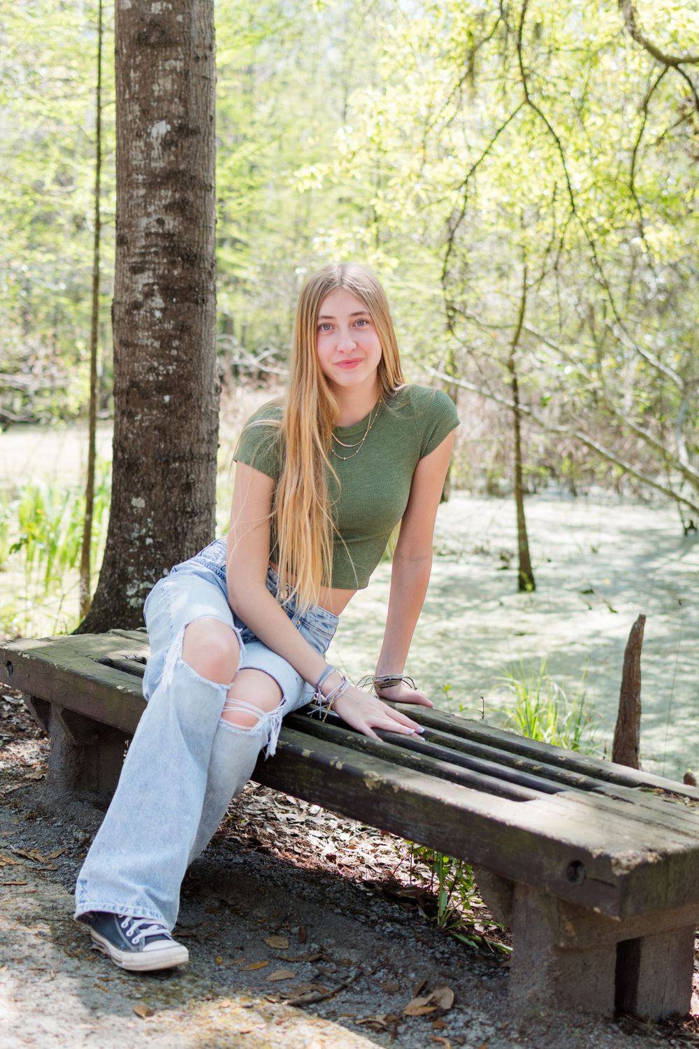 Casual portrait on a wooden bench in a scenic swamp setting.