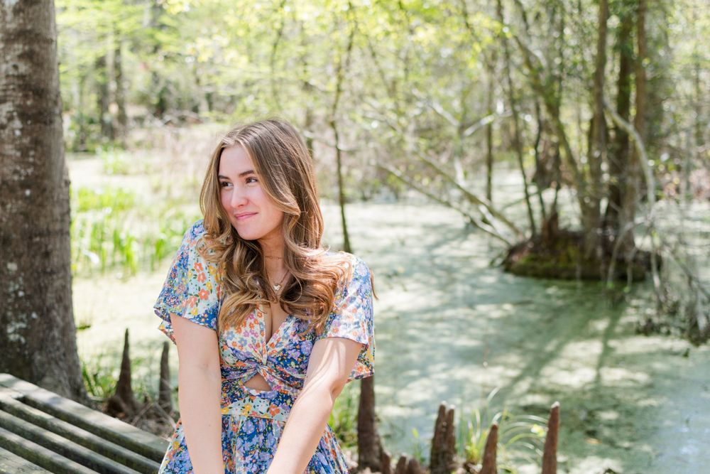Outdoor portrait by a peaceful stream in a wooded setting.