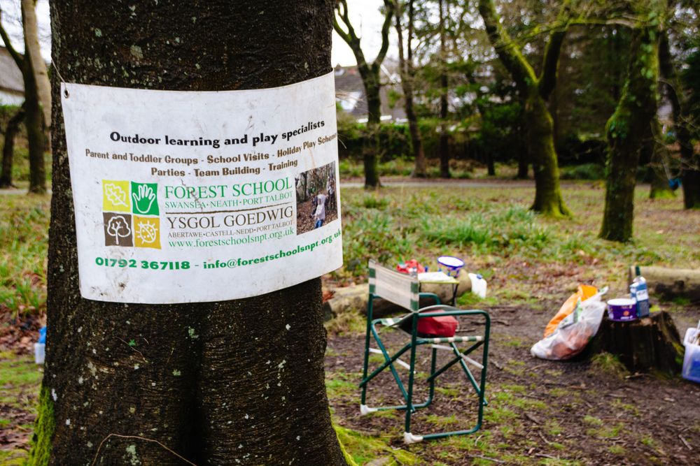 Notice posted on tree trunk with camping equipment visible in background.