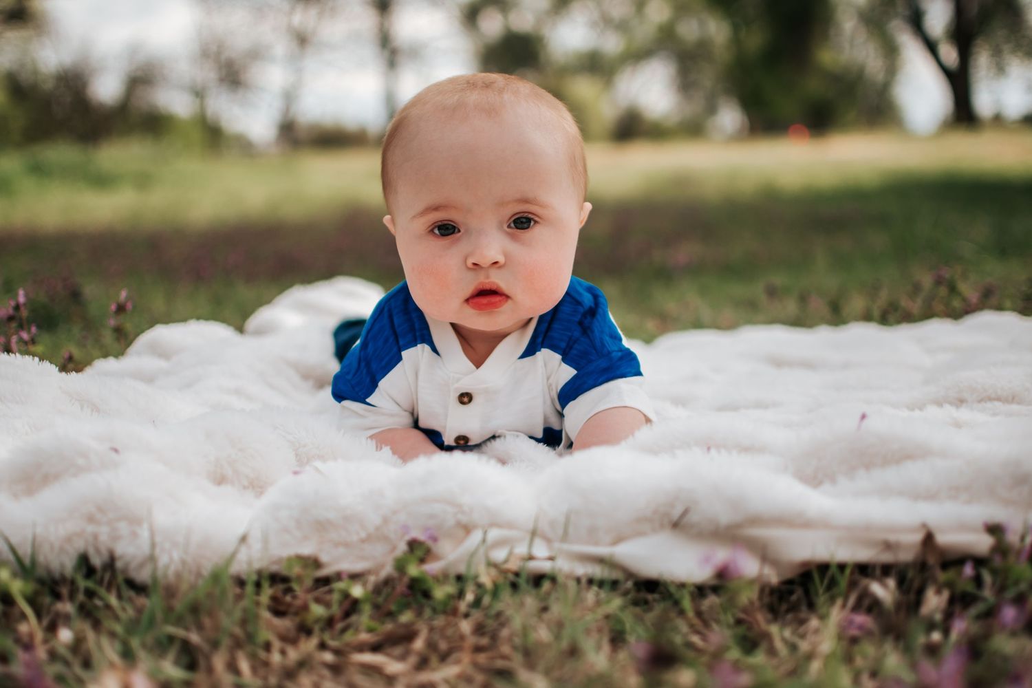 Baby lying on white blanket outdoors in Columbia Park in Kennewick, Washington.