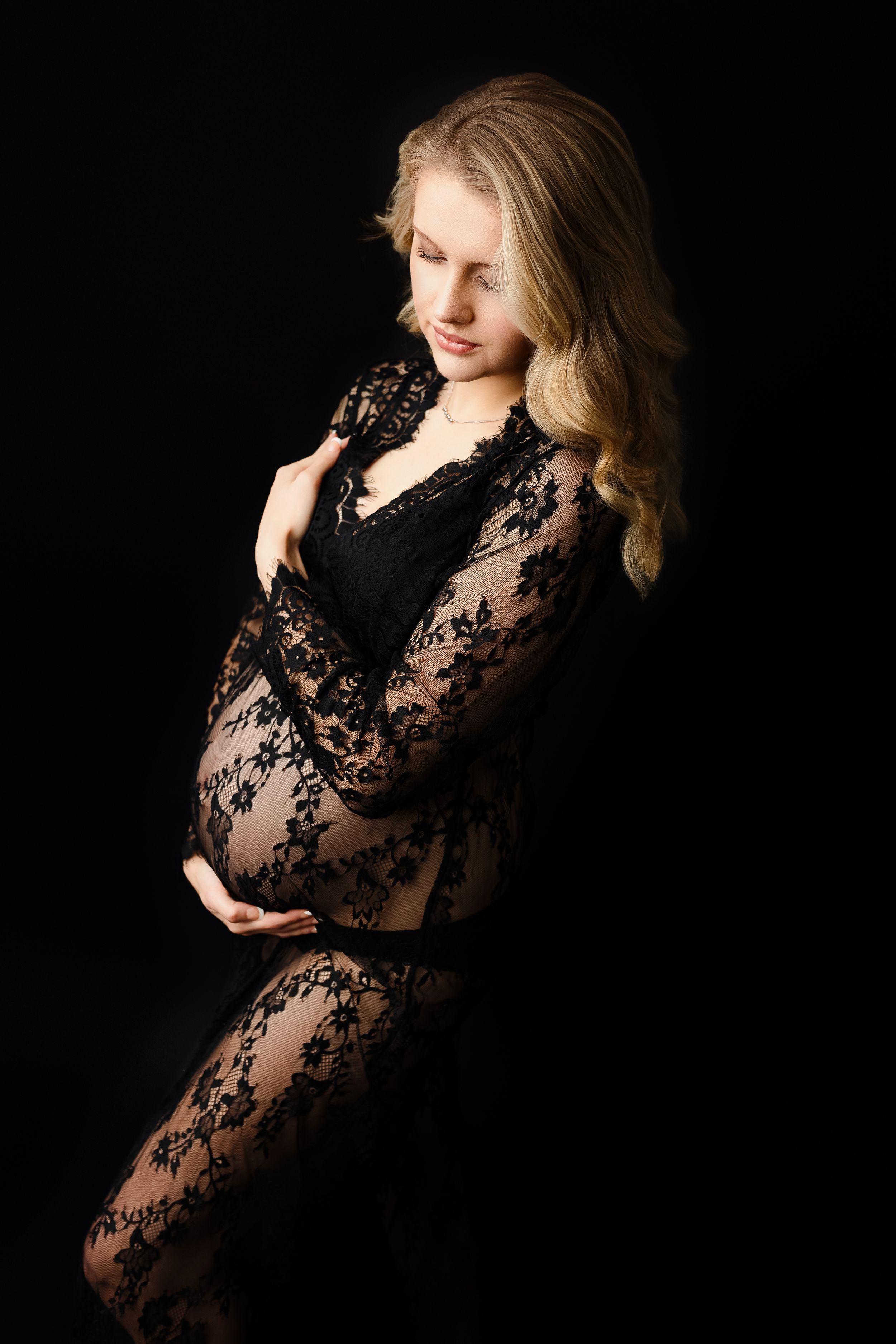 Elegant Lace Gown Maternity Portrait – Portsmouth, OH – A mother-to-be in a lace gown glows with joy in a timeless studio shot.