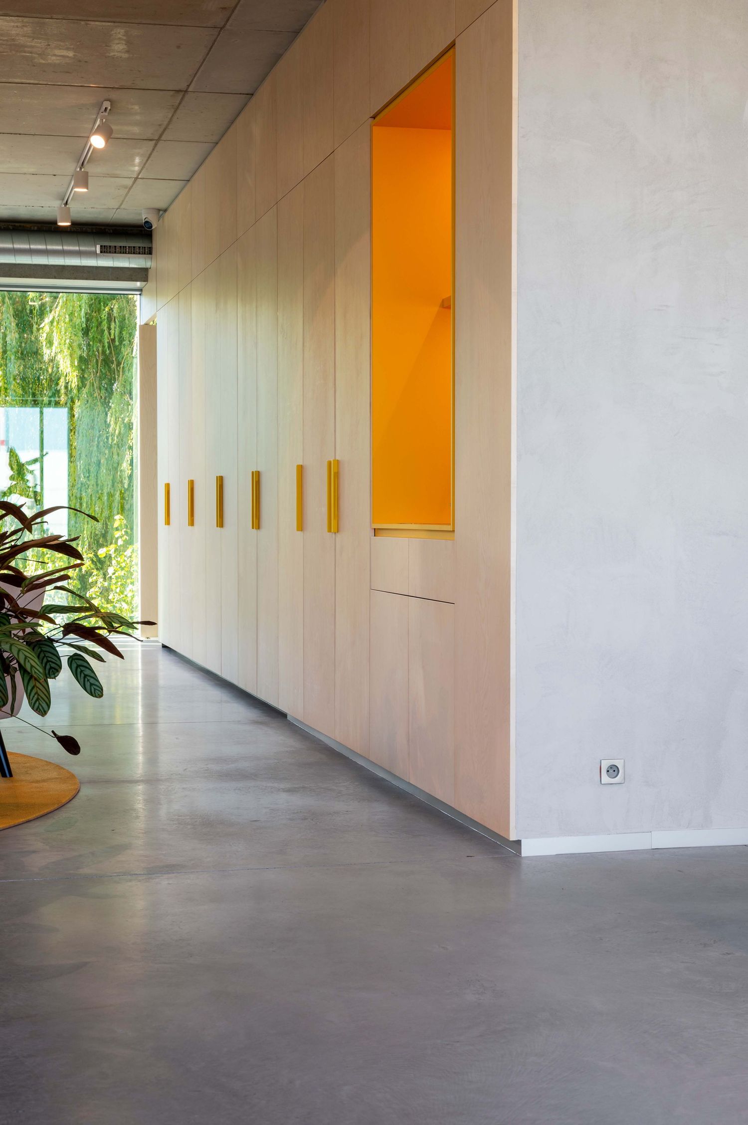 Modern interior space with white walls and yellow circular seating area on brown flooring viewed from above.