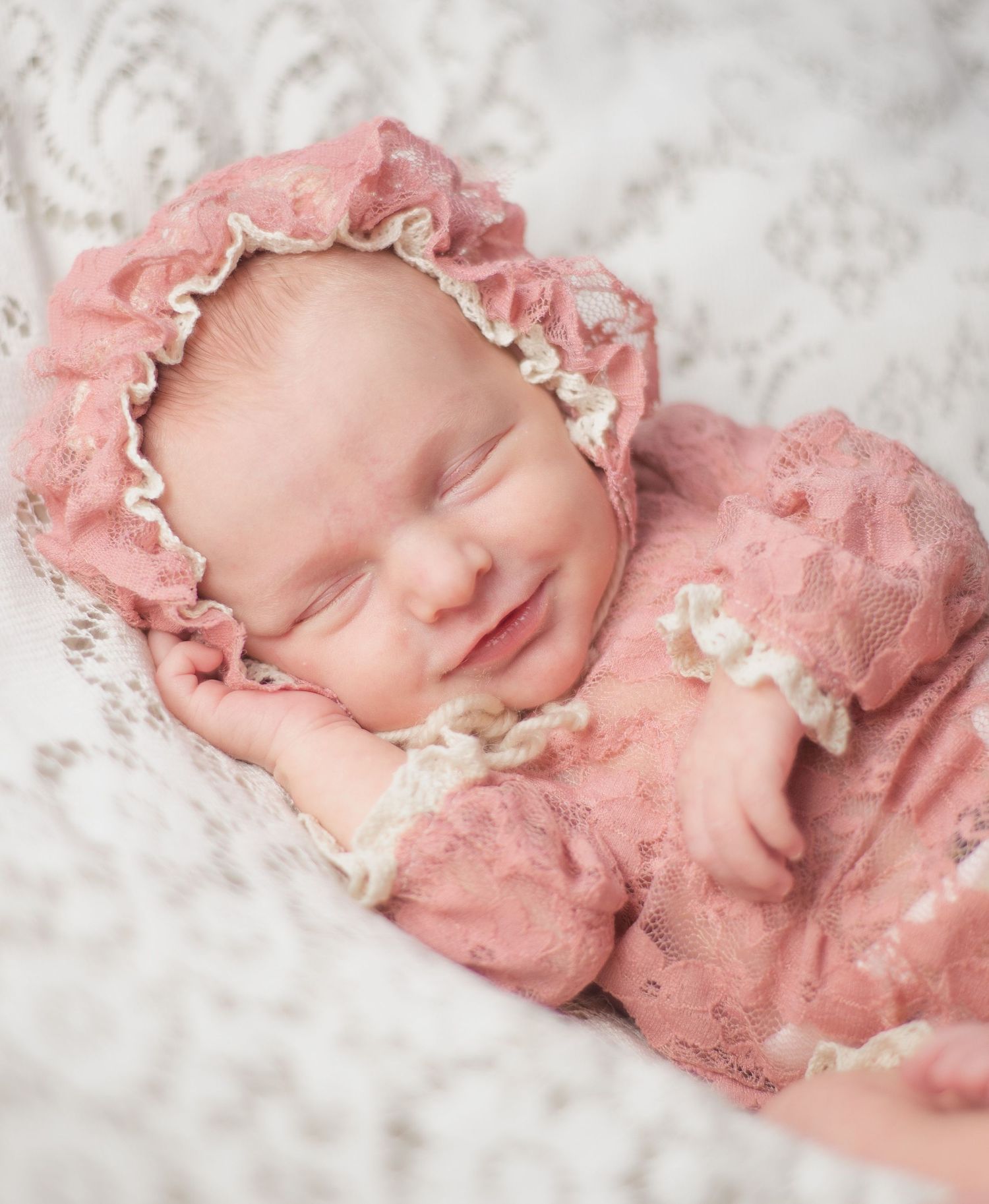 newborn baby girl smile in her sleet pink lace bonnet and outfit studio session Baldwin county Alabama