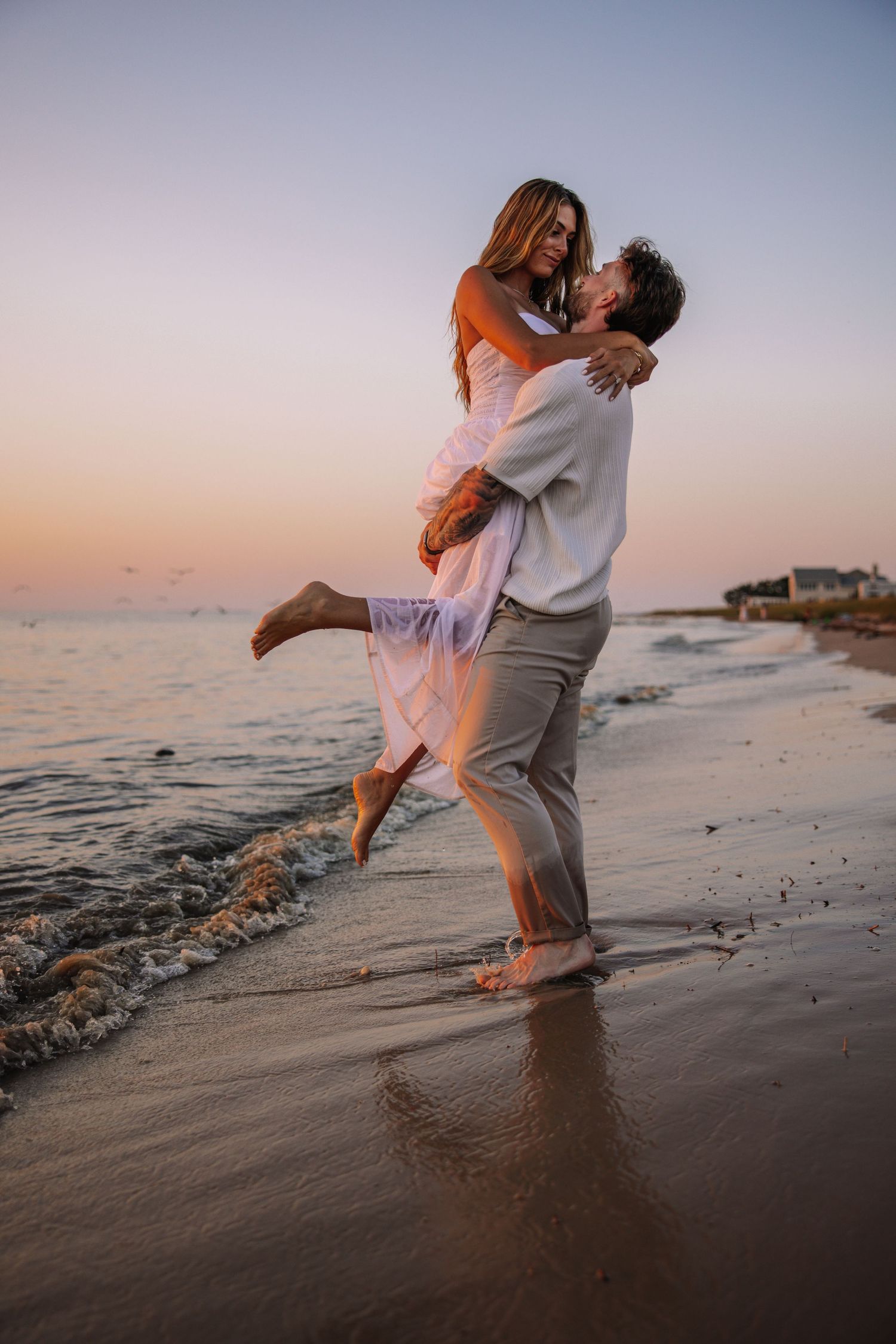 Joyful family moment captured during sunset on beach with ocean backdrop.