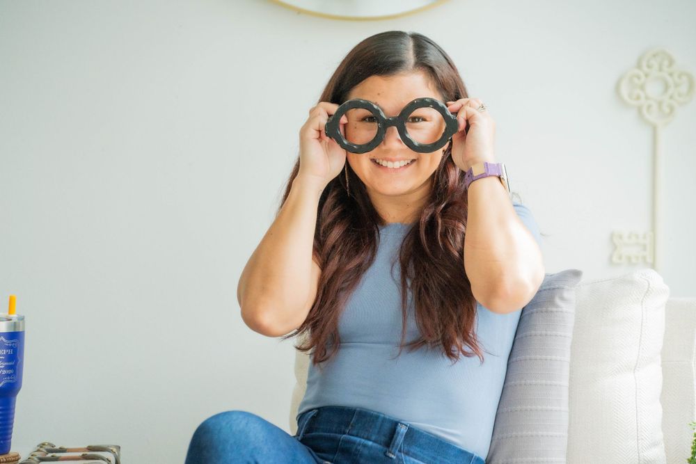 Playful moment with round glasses in casual home office setting.