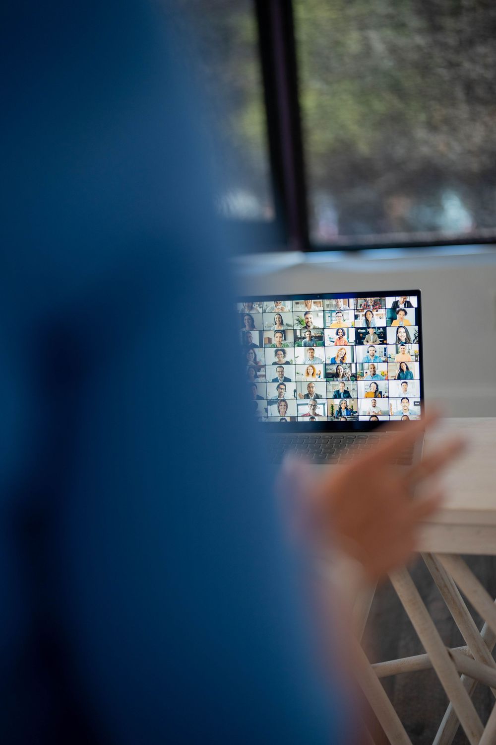 Computer screen showing grid of video conference participants in virtual meeting.