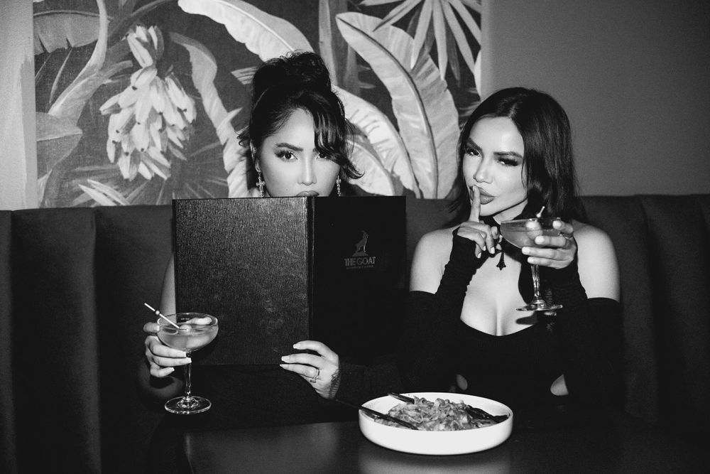 Black and white restaurant scene showing dining and drinks in atmospheric lighting.