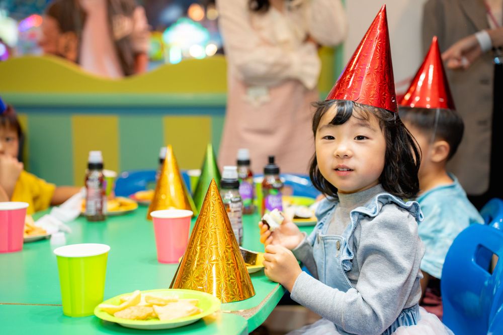 Candid kids event photography of a happy girl celebrating her birthday with friends at Rainbows End theme park in Auckland.