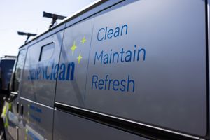 Close-up view of text reading 'Clean Maintain Refresh' on the side of a dark colored service van.
