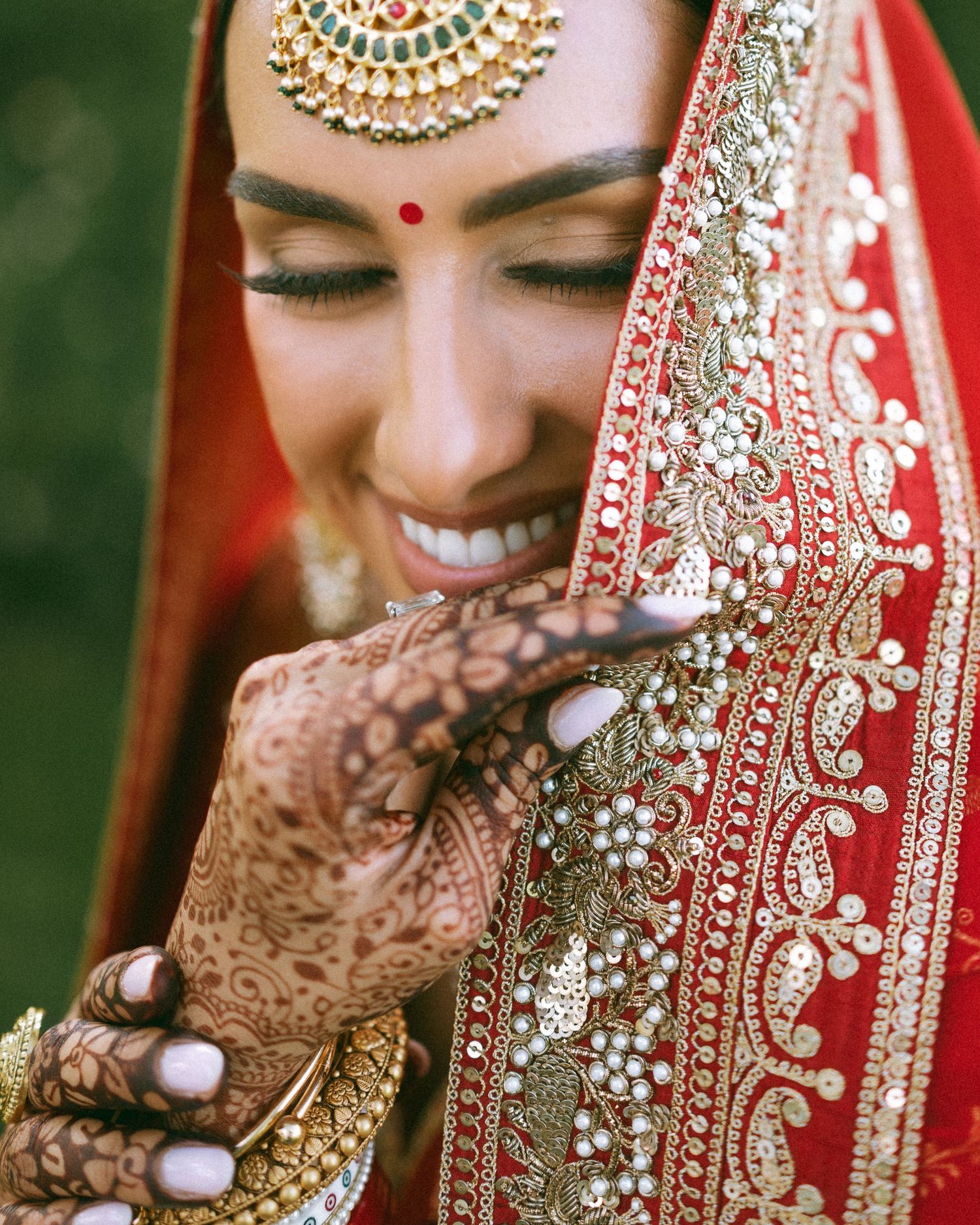 Romantic couple embrace in garden setting wearing yellow and silver traditional formal attire.