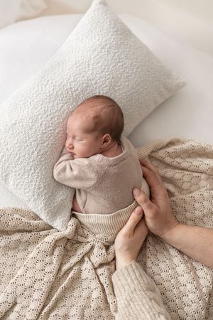 Natural newborn photography Nottingham NG16 baby sleeping in soft blanket and detailed parents hands