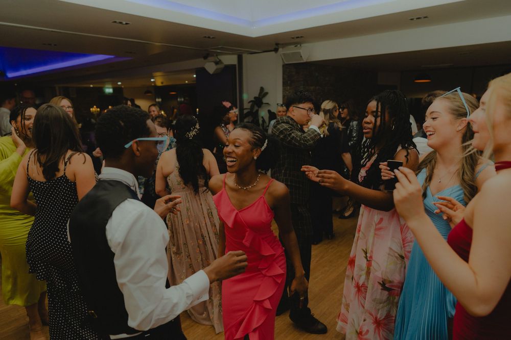 Guests dancing and celebrating at an elegant indoor party event with colorful formal attire.