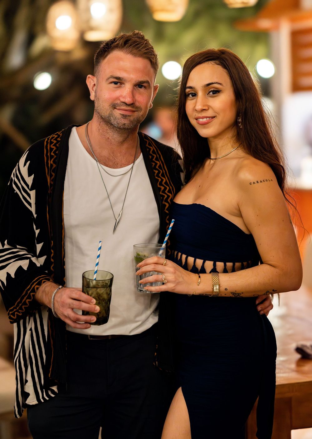 A couple enjoying drinks together at a dimly lit bar in a series of romantic candid photos.