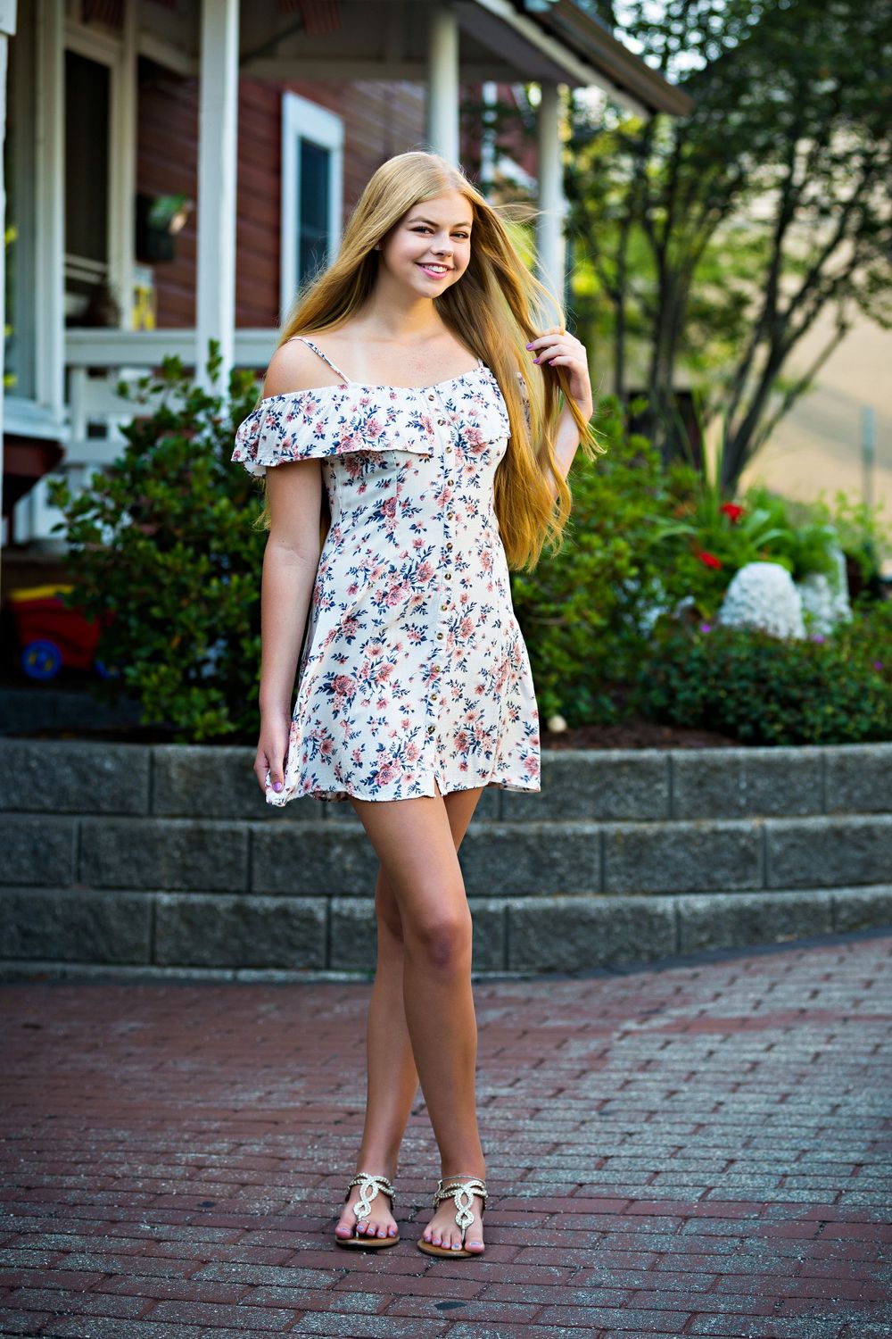 Summer fashion portrait in floral off-shoulder dress near red house. Grand Rapids Photographer