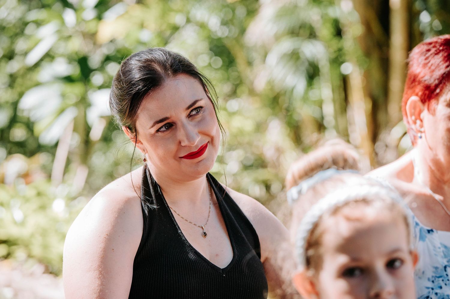 A guest smiling at an outdoor garden party.