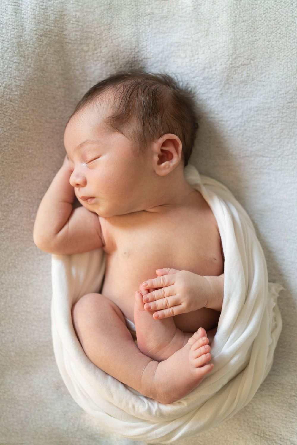 fotografia newborn a domicilio, neonata sveglio, neonata con occhi aperti, foto a casa Peschiera Borromeo, a Milano, fasciatura con wrap