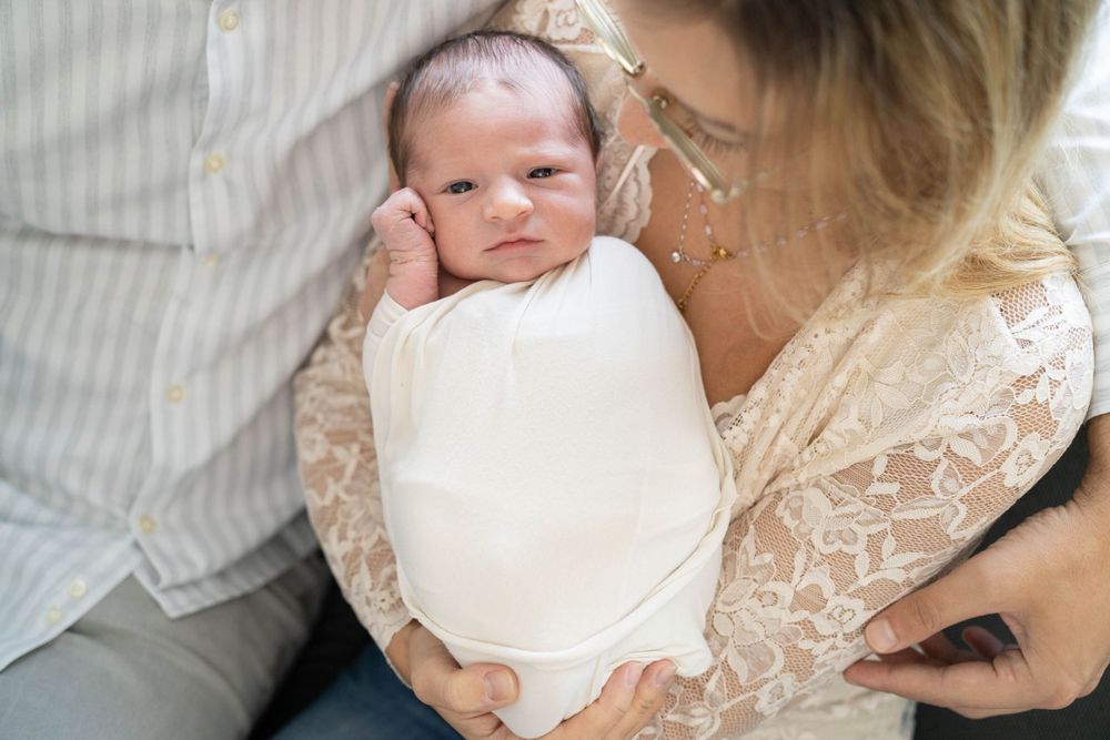 fotografia newborn a domicilio, neonata sveglio, neonata con occhi aperti, foto a casa Peschiera Borromeo, a Milano, fasciatura con wrap