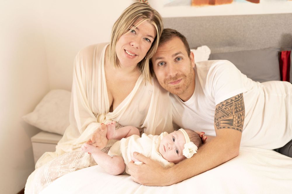 sessione fotografica baby a domicilio, bimba di due mesi tra mamma e papà, fotografia di famiglia a domicilio, neonata due mesi