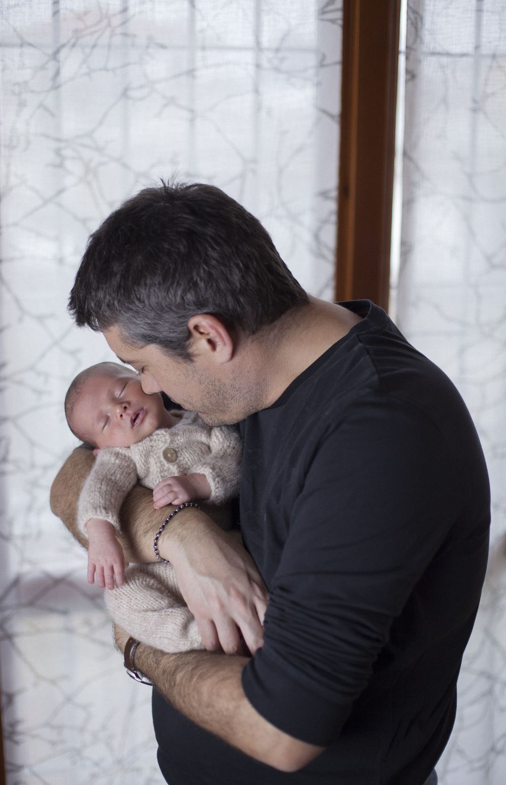 papà con figlio in braccio, sessione famiglia, sessione fotografica newborn a domicilio a Peschiera Borromeo, sessione baby provincia Milano