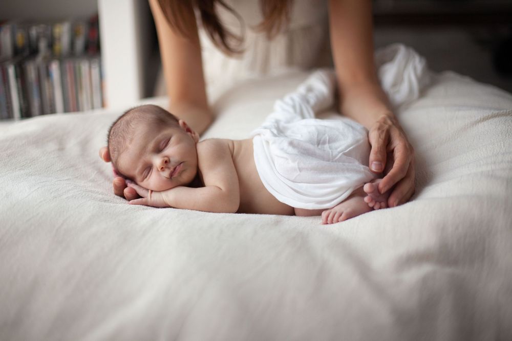 neonata che dorme. fotografia neonati fotografa neonati a domicilio, neonata tra le mani della mamma
