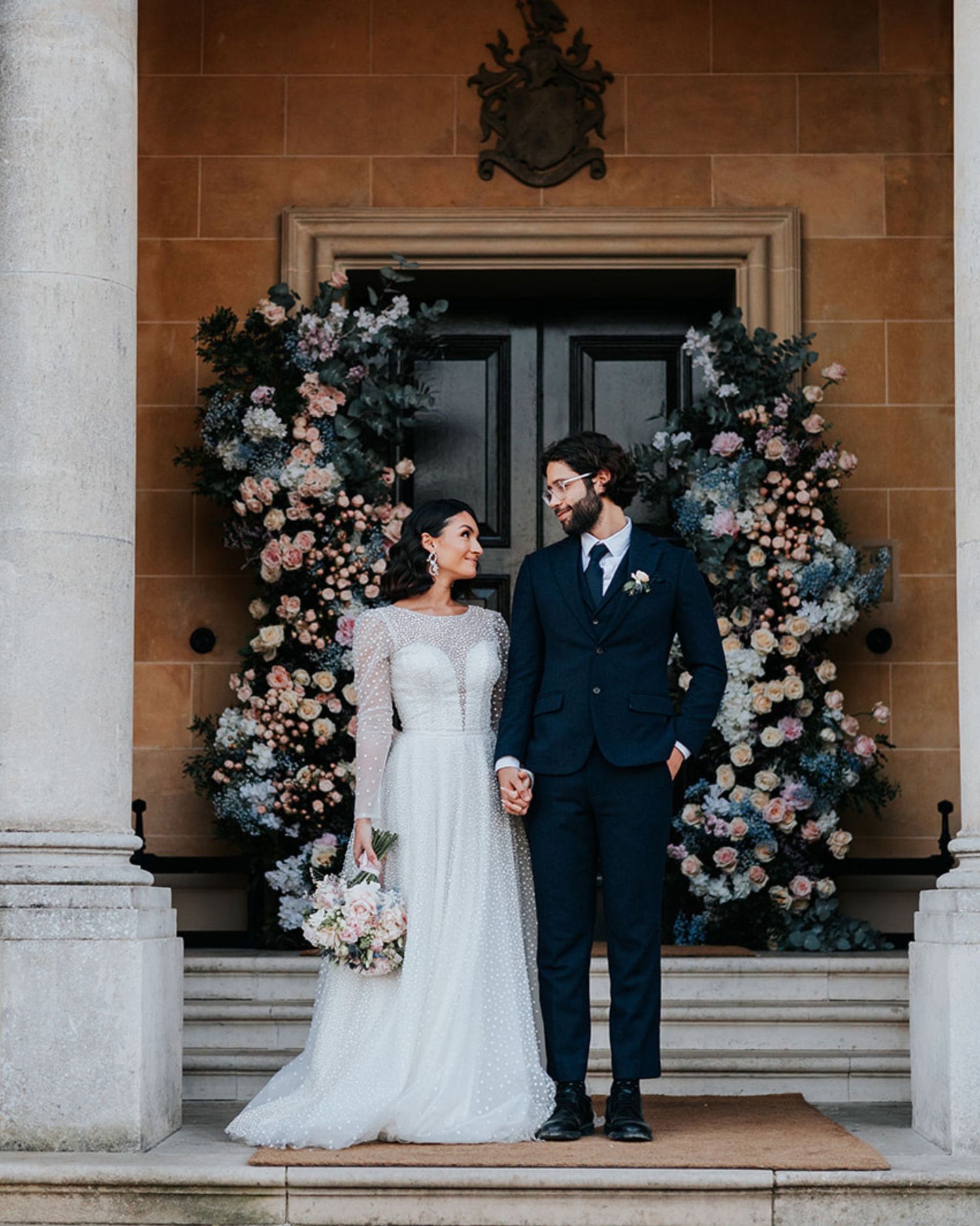 A wedding celebration moment captured through shower of flower petals and confetti with an aqua umbrella in background. Hampshire