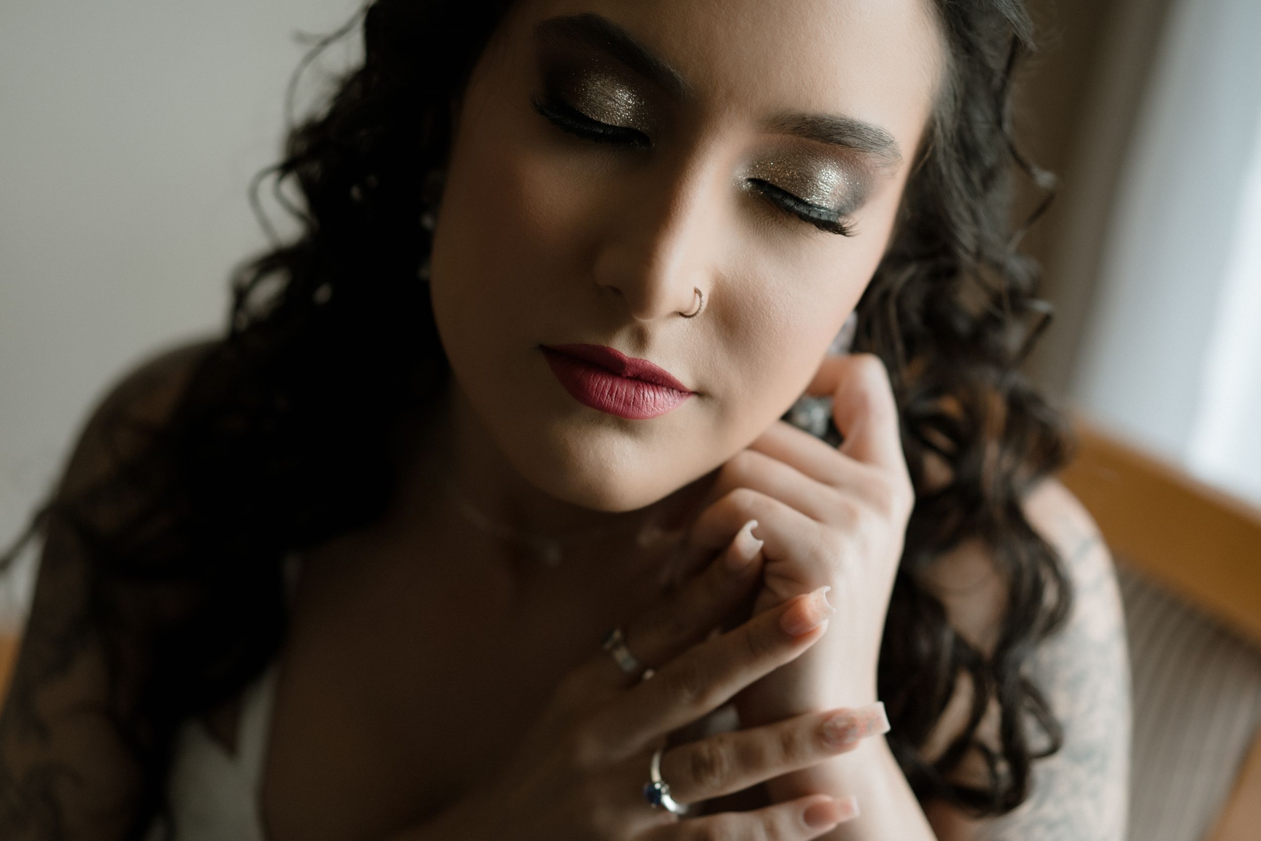 Elegant close-up portrait with dramatic makeup and curled hair.