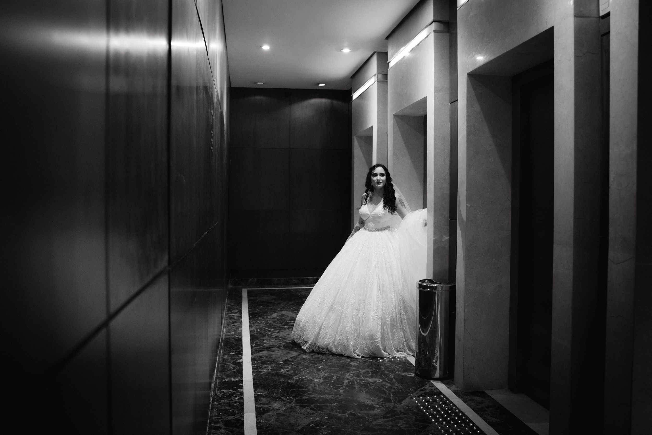Dramatic black and white photo in modern hallway with evening gown.
