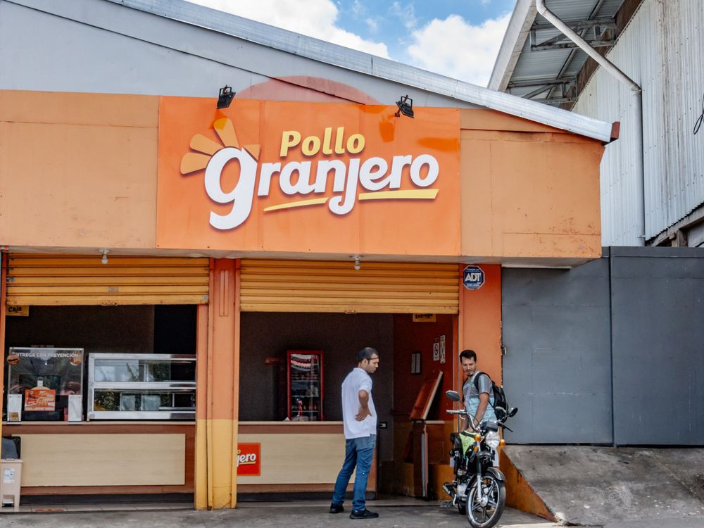 Orange storefront of Pollo Granjero restaurant with modern signage.