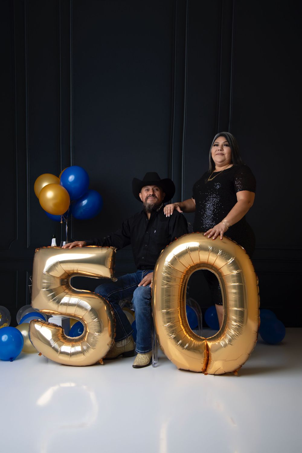 Creative birthday setup with large gold number 50 balloons and blue accents.