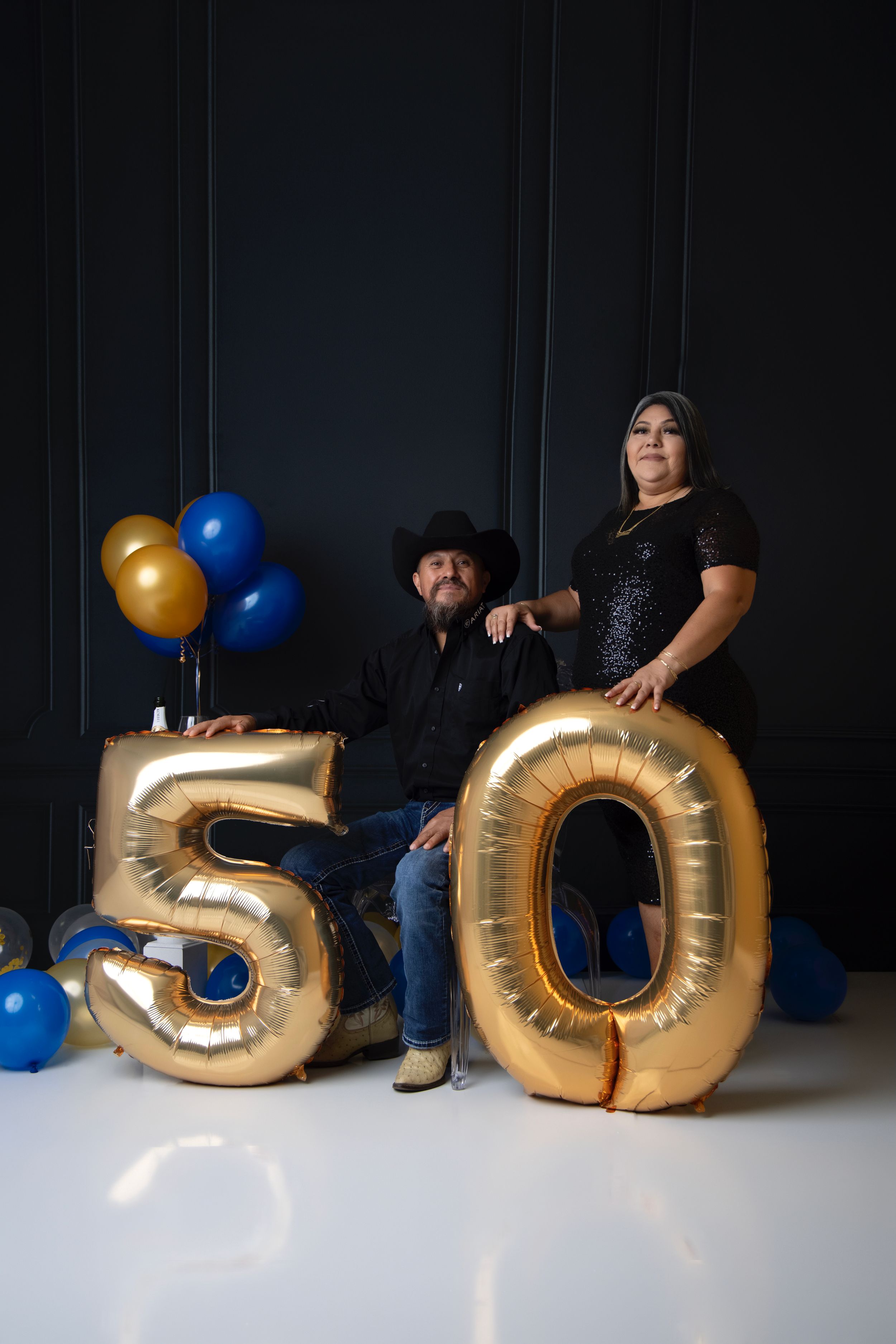 Creative birthday setup with large gold number 50 balloons and blue accents.