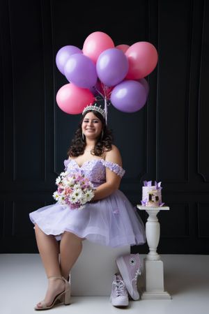 Birthday celebration shoot with purple and pink balloons, tulle dress, and cake.