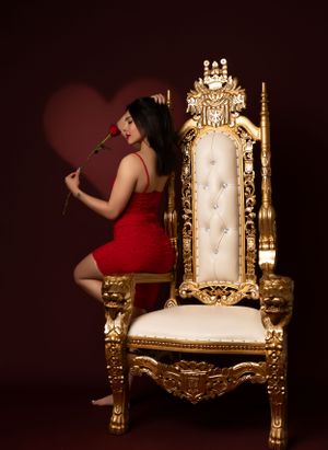 Elegant boudoir photography featuring gold baroque throne chair in dark moody lighting.
