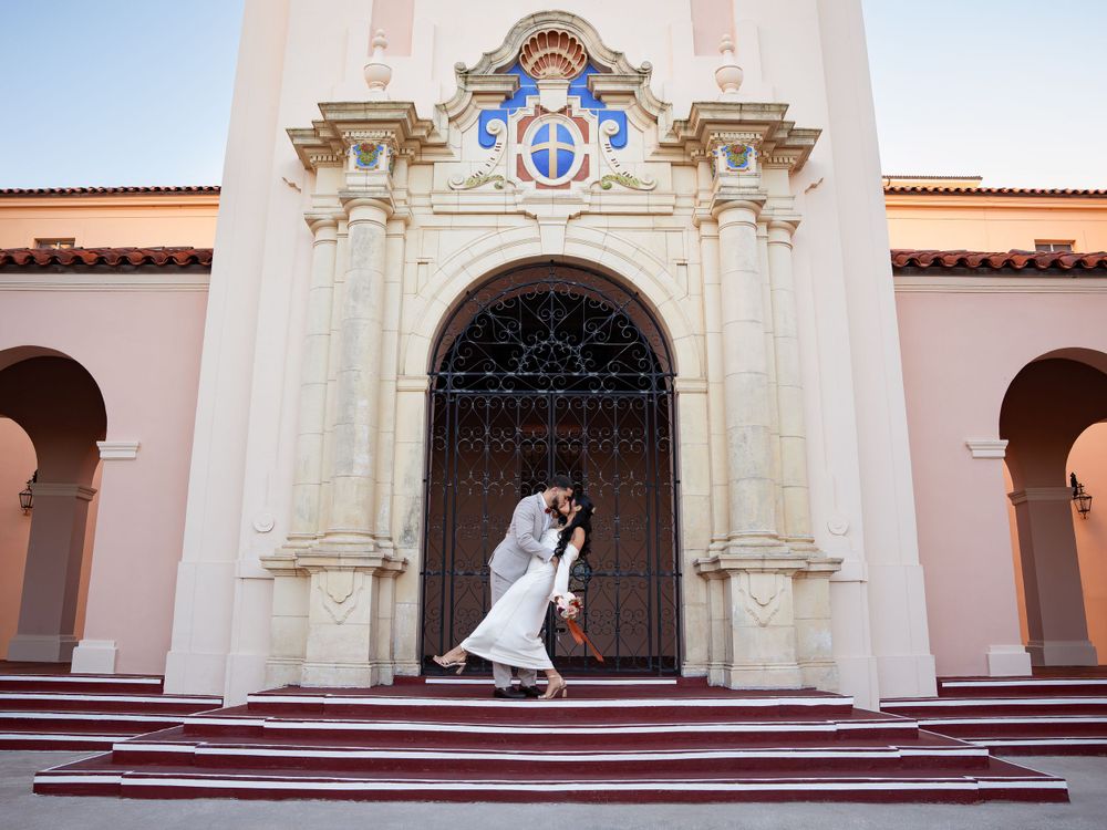 A couple poses during their wedding in front of the Sarasota Courthouse in Sarasota, Florida.