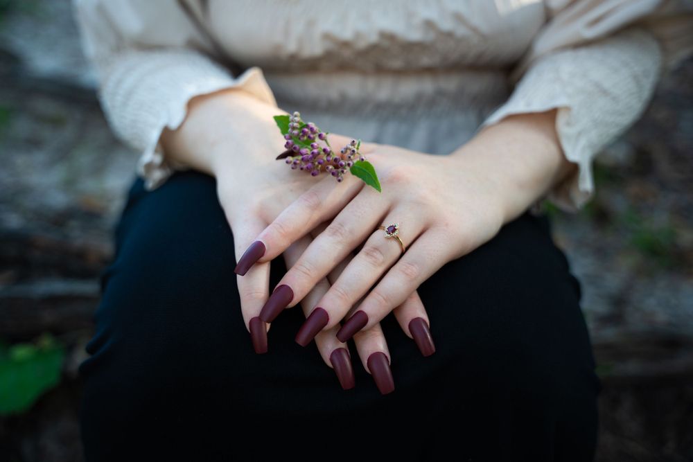 Engagement photo hand posing with flowers with vintage red jewel garnet ruby engagement ring