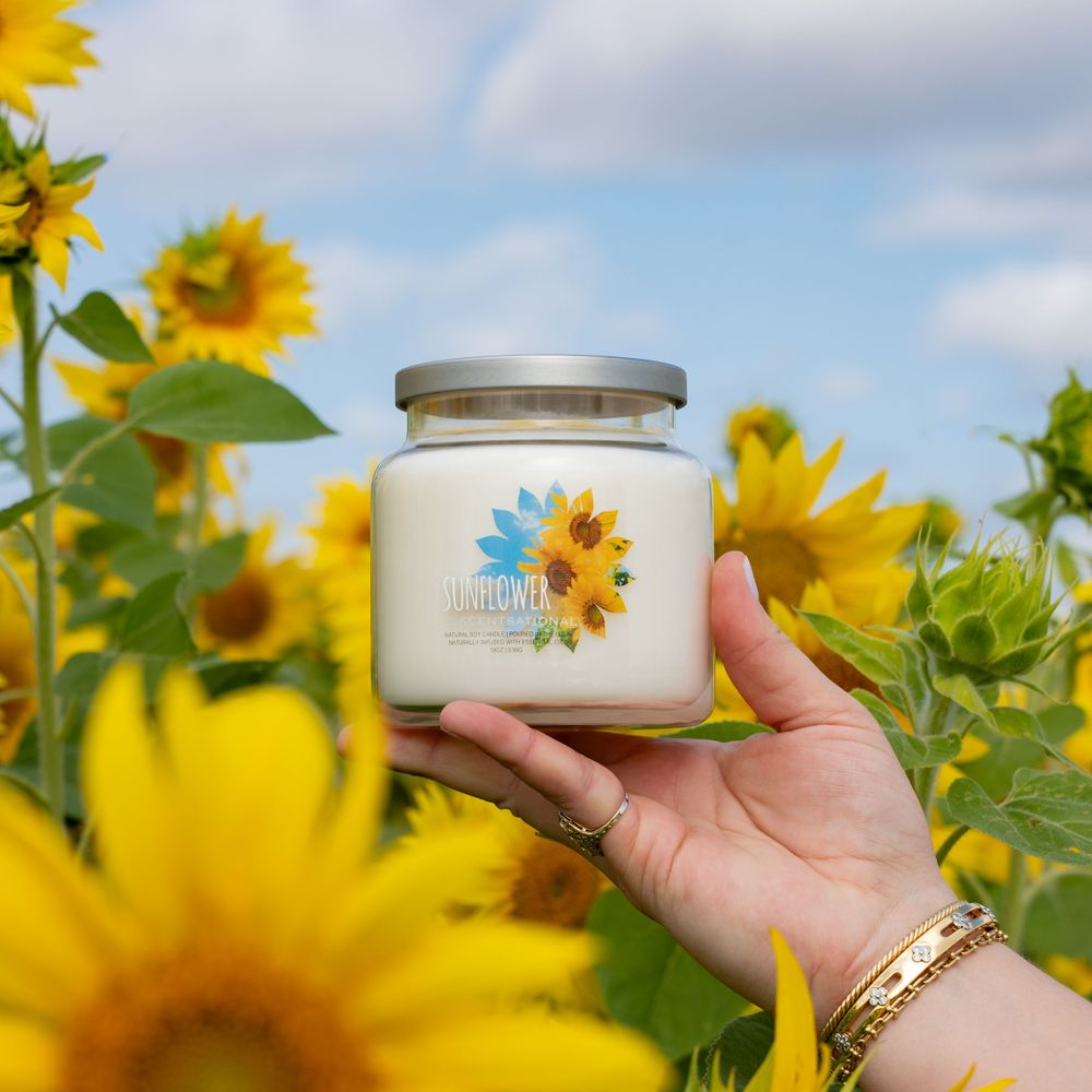 Candle product photography lifestyle image with sunflowers