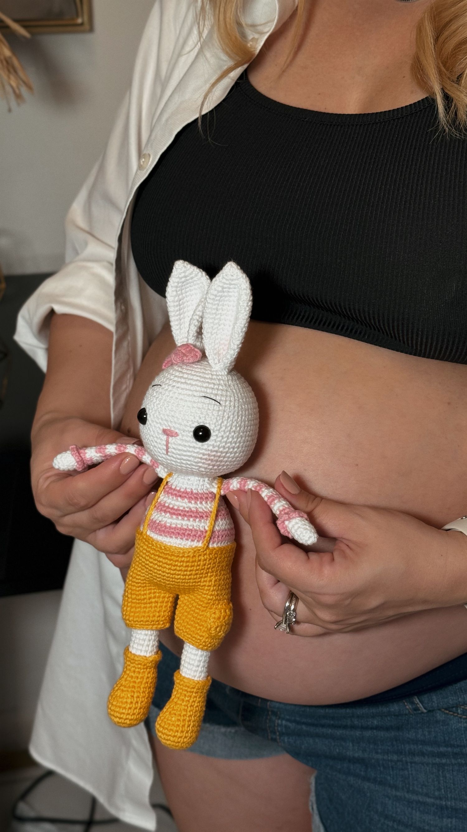 Maternity photo with a baby toy - close-up of belly and stuffed animal