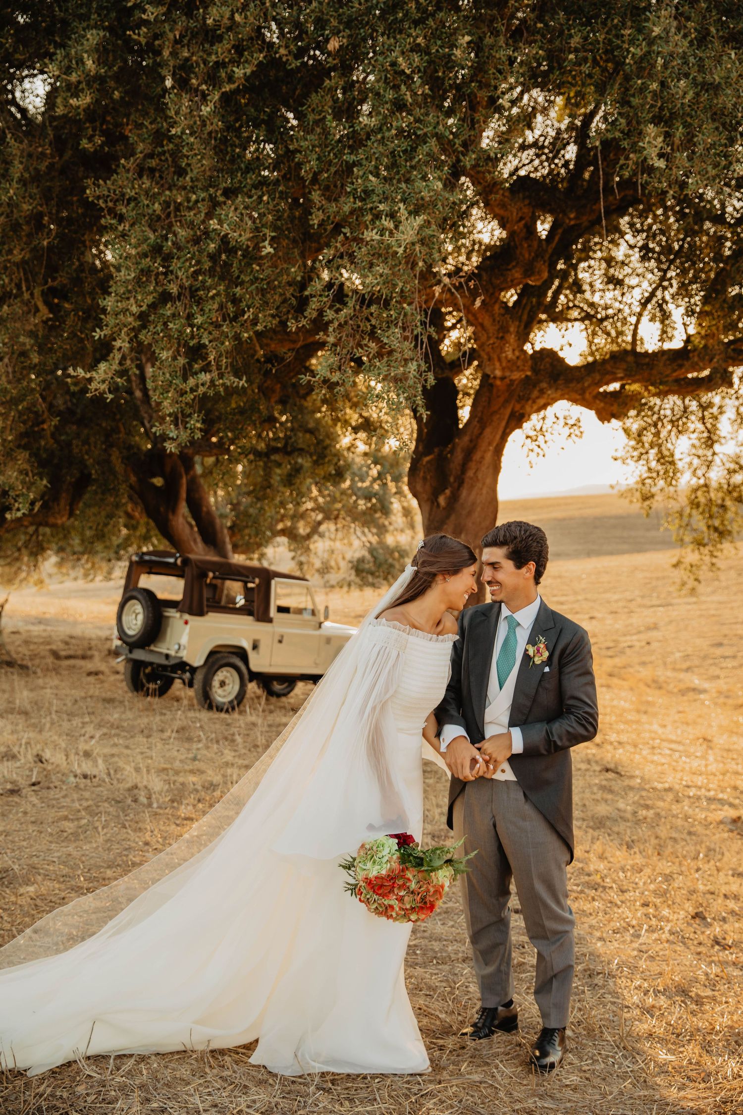 A romantic sunset photoshoot showing a tender embrace between two people in warm golden lighting.