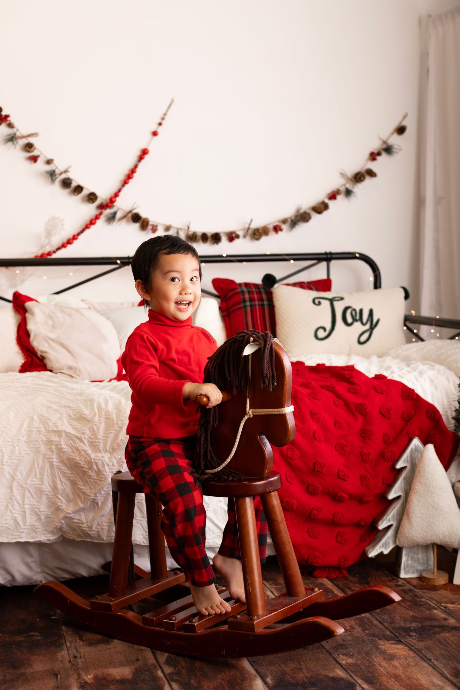 A decorated holiday scene with a rocking horse and red plaid Christmas decor.