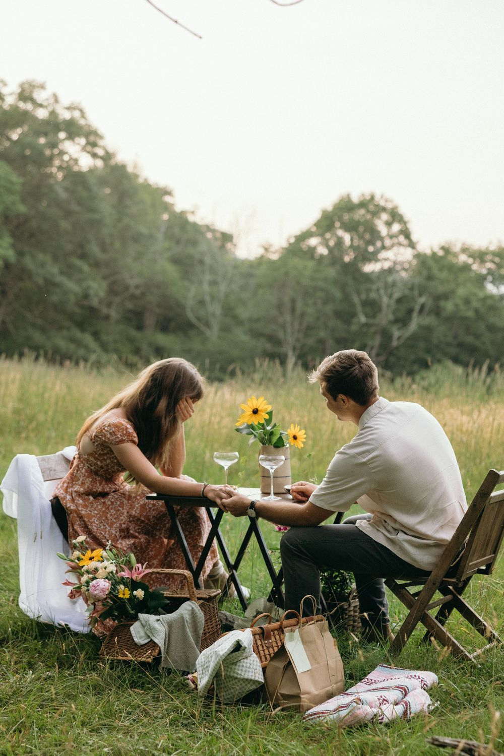 Casual outdoor dining scene with folding chairs and sunflowers in a meadow. Luxury Estate Wedding Photographer in NC