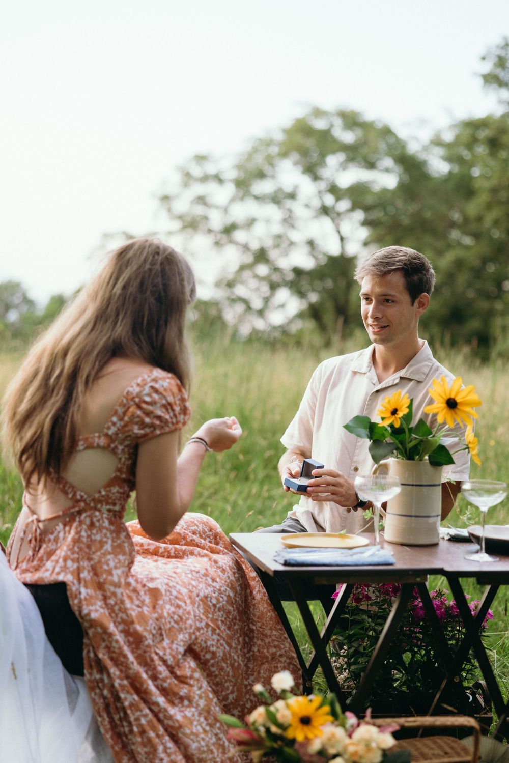 Outdoor dining scene with sunflowers and vintage-style table settings in natural light. Luxury Estate Wedding Photographer in NC