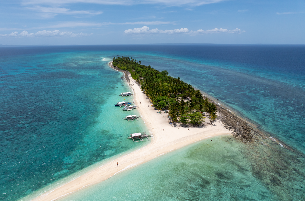 Aerial view of tropical island paradise with white sand beach and turquoise waters.