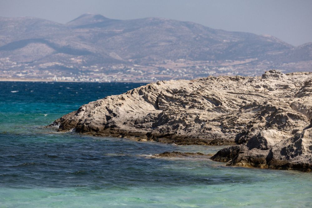 Rocky coastal landscape with turquoise waters and mountains in the Mediterranean.