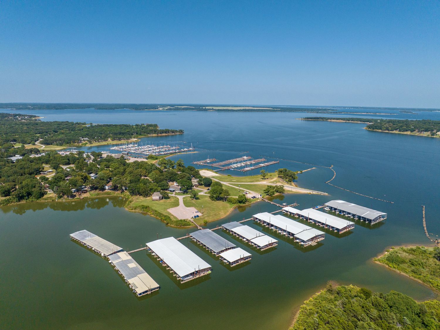 Aerial view of waterfront development with boat docks and marina facilities.