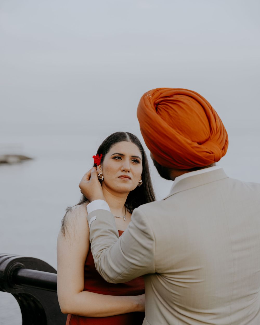 A tender moment between a couple against an overcast sky.