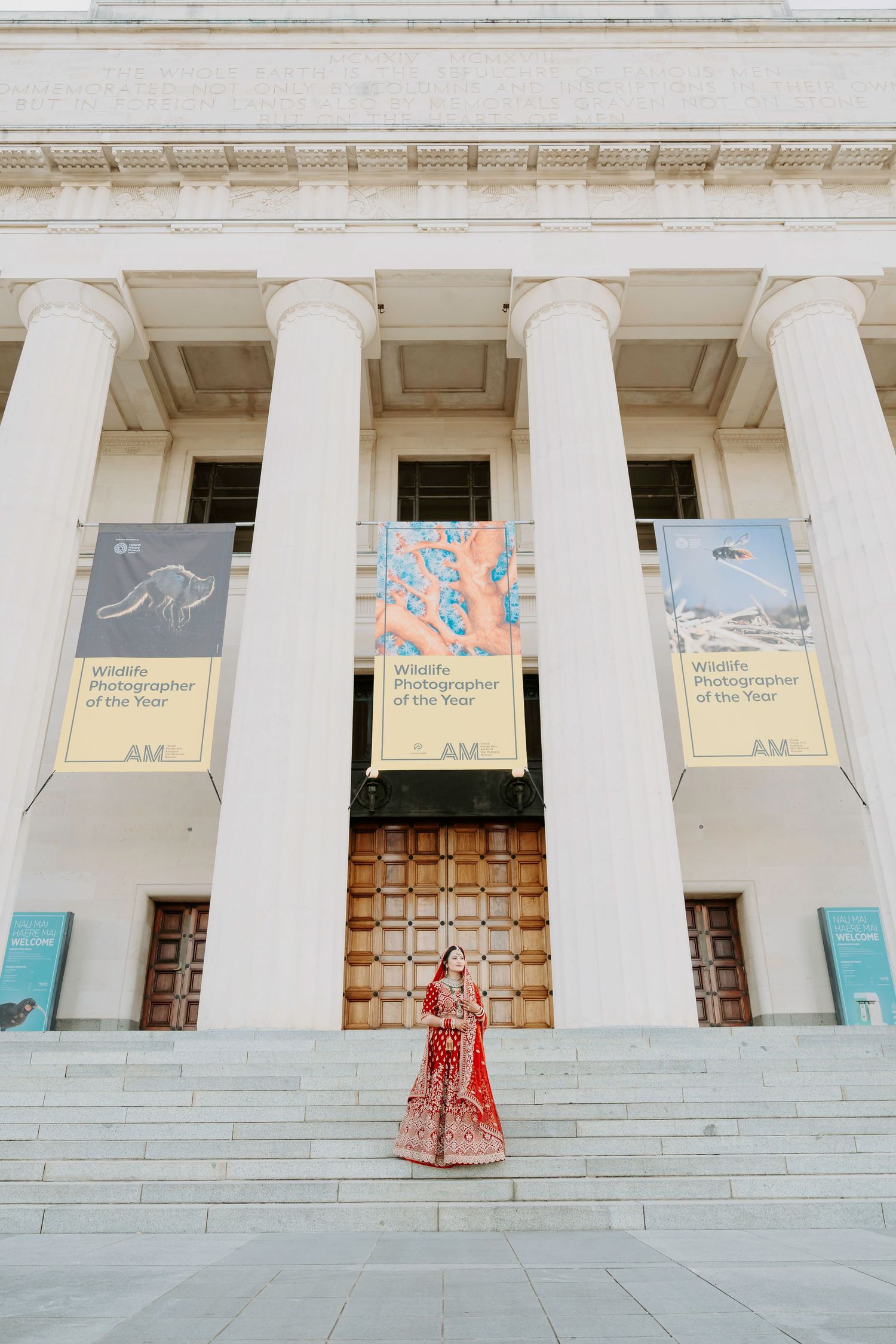 Classical building with white columns displaying art exhibition banners.