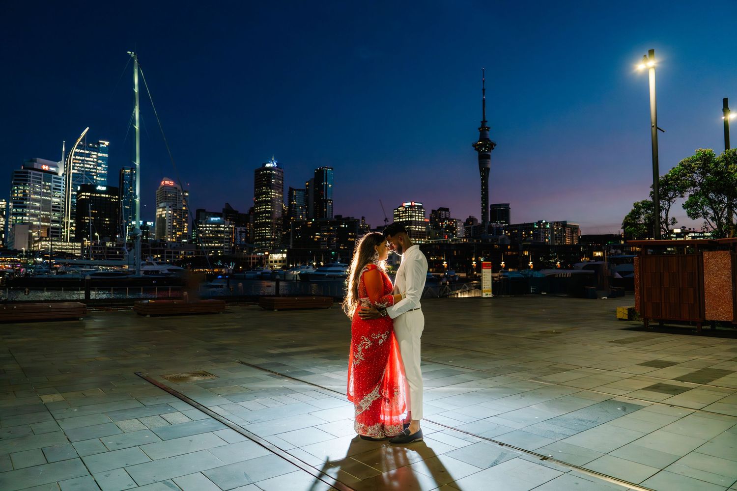 A romantic evening photoshoot against the Auckland city skyline at night.