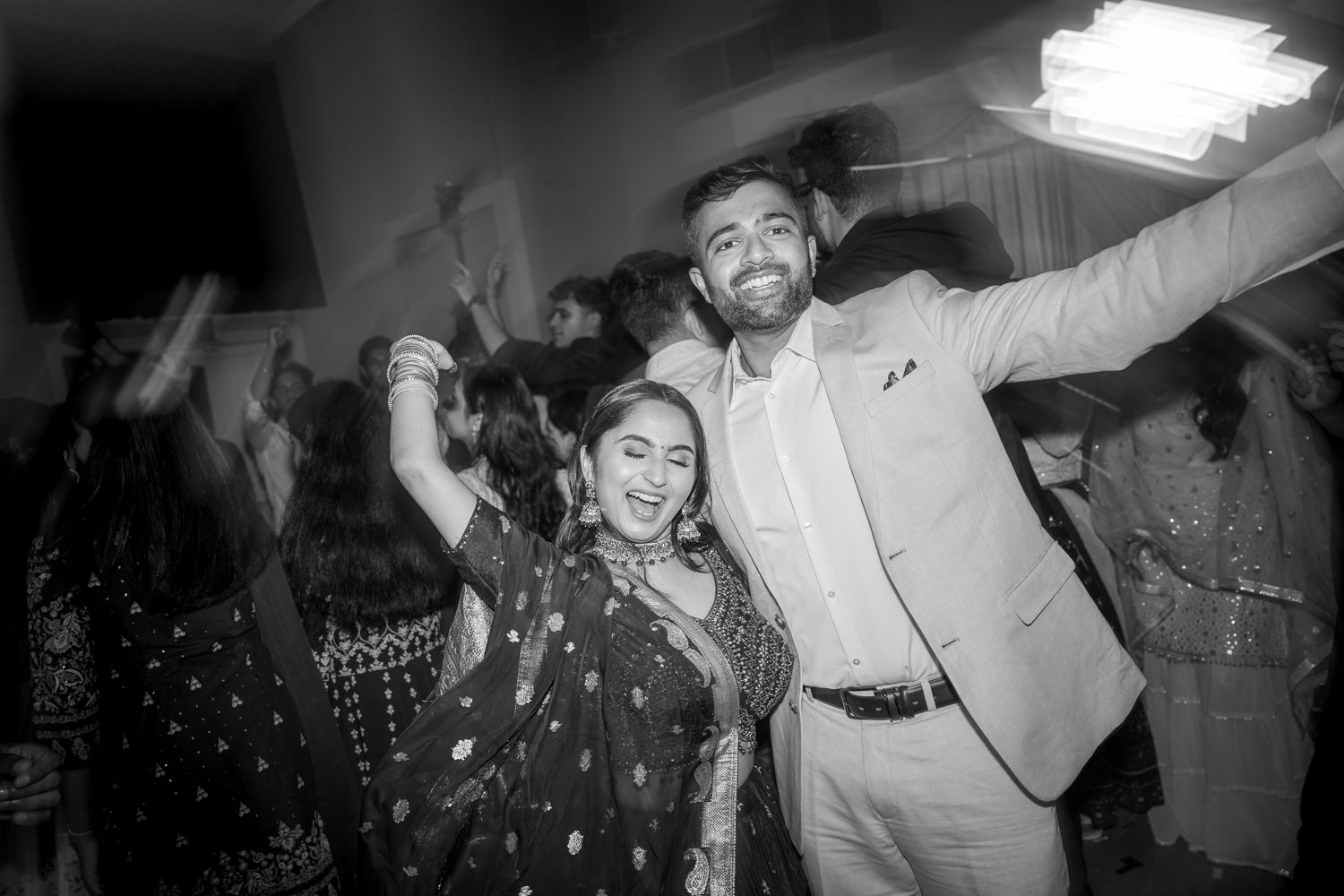 Black and white candid party photo of celebrating guests with vintage film effect.