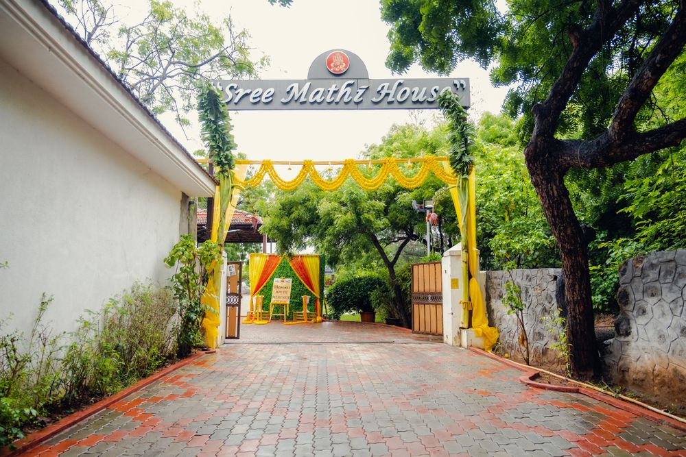 Yellow entrance arch with decorative flags leading to a garden pathway.